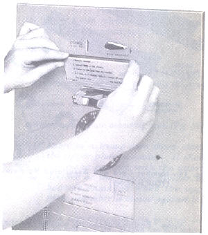 Installing an upper instruction card in a 2A payphone.